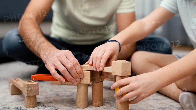 Father child playing with toys front view