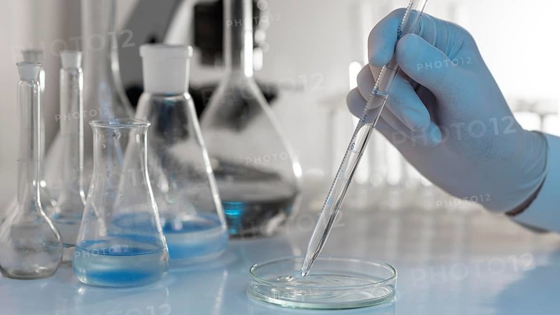 Close up hand holding lab pipette