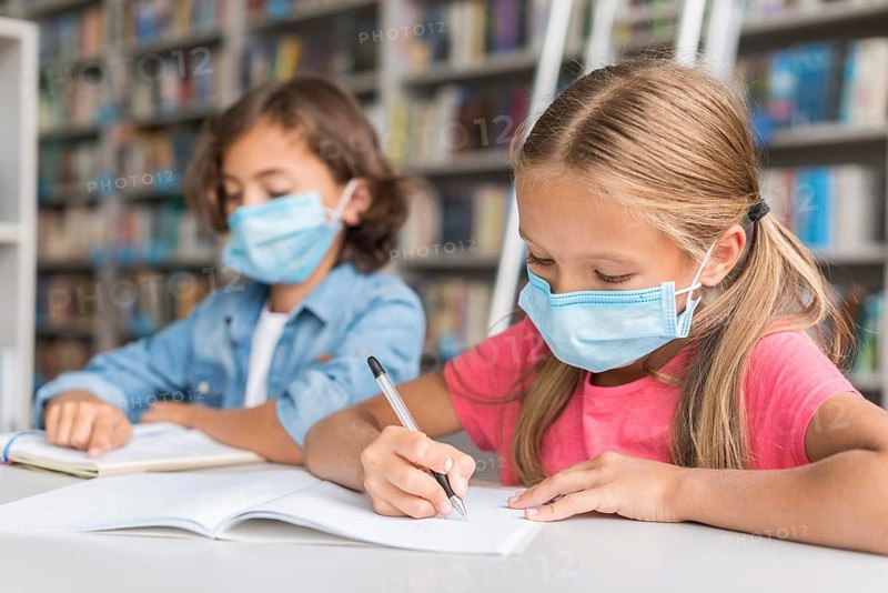 Kids doing homework while wearing face masks