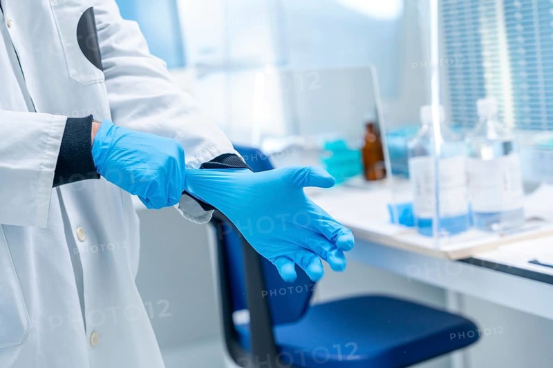 Close-up of a doctor using blue latex gloves in the laboratory of an hospital