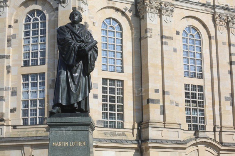 A statue of Martin Luther, preacher, translator and father of the Reformation in front of the Frauenkirche on a bright day., Dresden, Germany, Europe