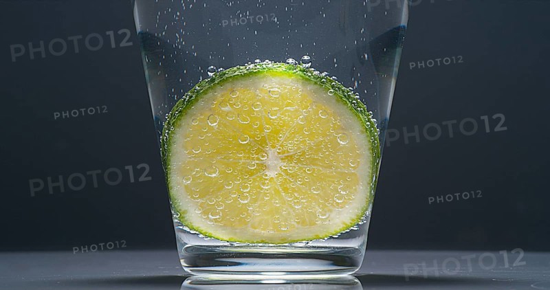 Slice of Green Lemon (citrus aurantifolia), in a Glass