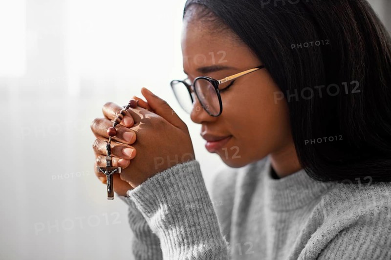 Religious woman holding rosary beads