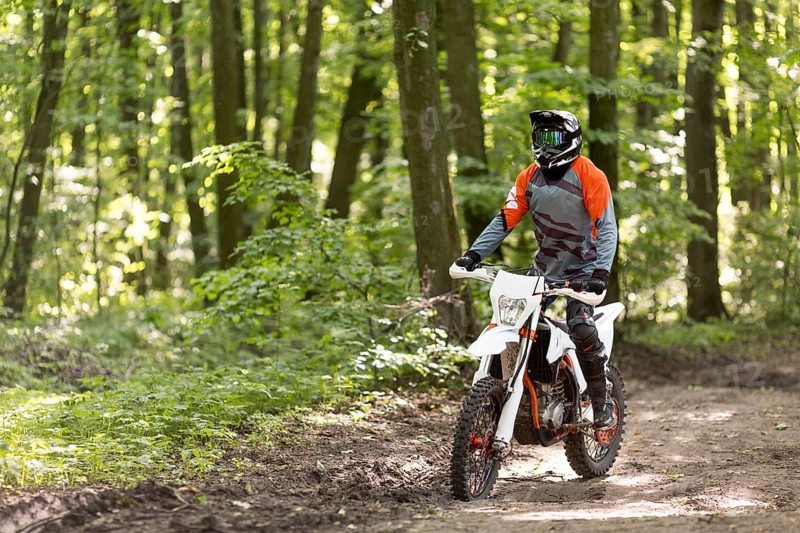 Active man riding motorcycle forrest