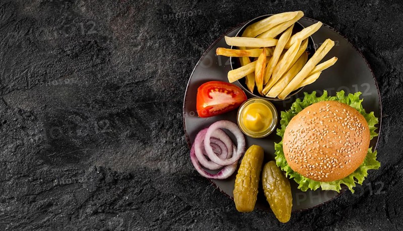Top view burger fries plate with pickles copy space