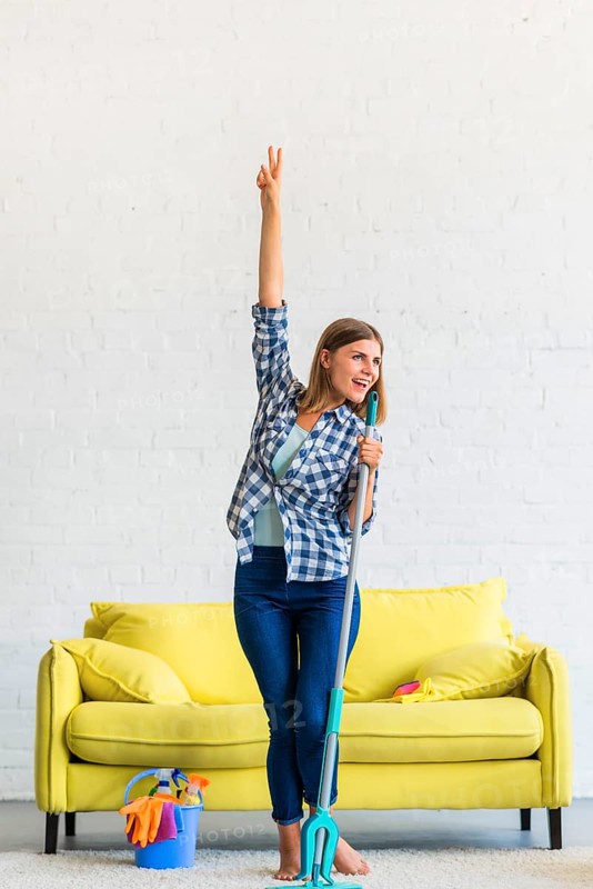 Happy woman dancing with mop home