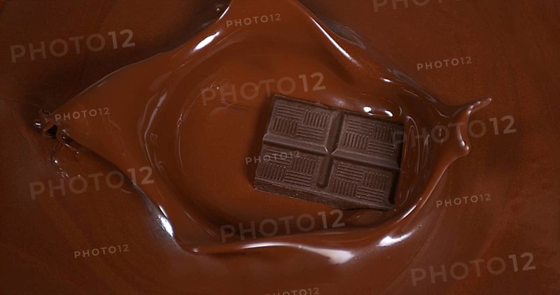 Black Chocolate tablet falling into Milk Chocolate