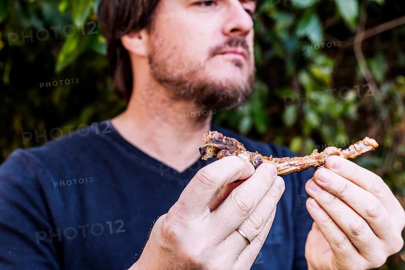 Close up man eating meat