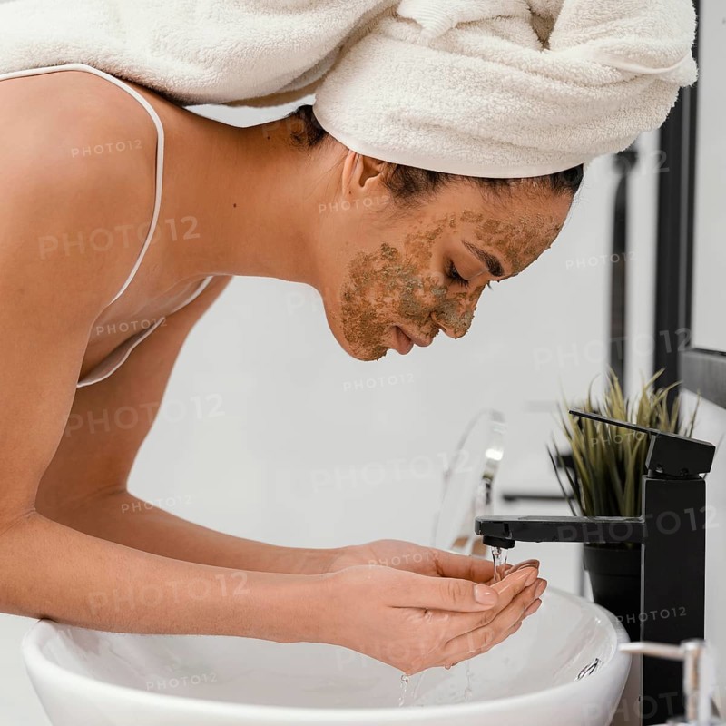 Woman washing her face after having homemade mask