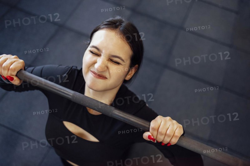 Gym woman doing push up exercises with dumbbells. Strong brunette female doing crossfit workout