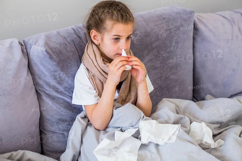 Little girl using nose spray