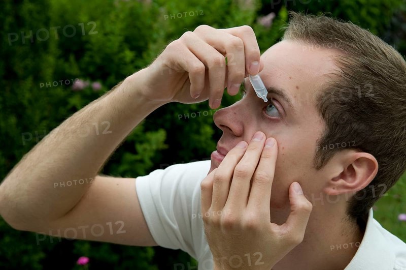 Young man takes eye drops, allergy, pollen allergy