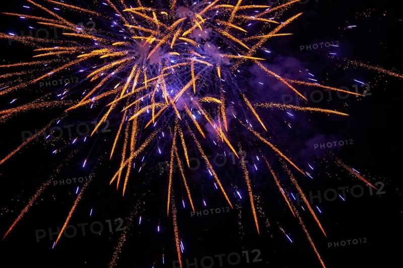 New Year's Eve fireworks night sky with golden and violet sparks