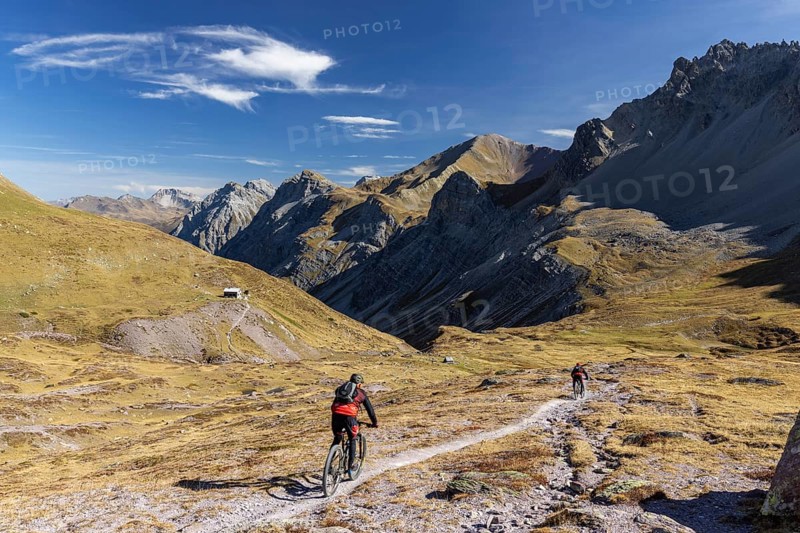 Alp Ramoz with Ramozhütte SAC, mountain biker on a trail, view into Welschtobel, behind Davos Alps with Weissfluhjoch, Alvaneu, Grisons, Switzerland, Europe