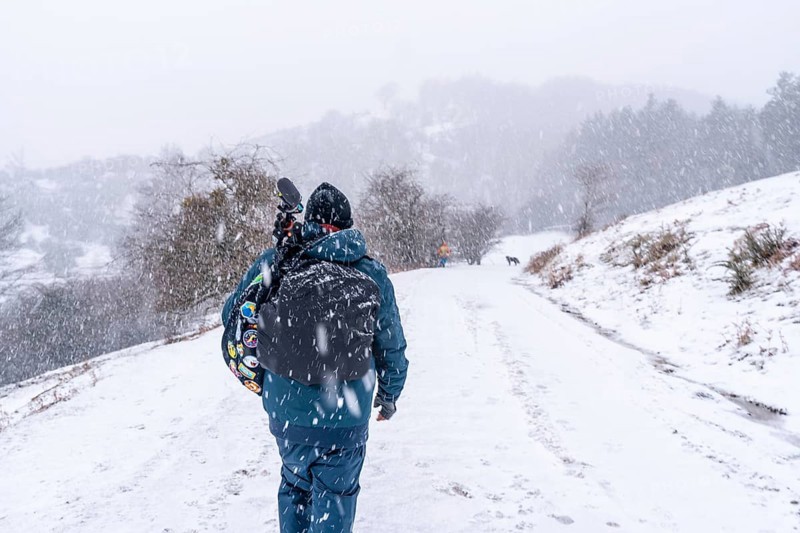 A young photographer walking in the aizkorri mountain of gipuzkoa. Snowy landscape by winter snows. Basque Country, Spain, Europe