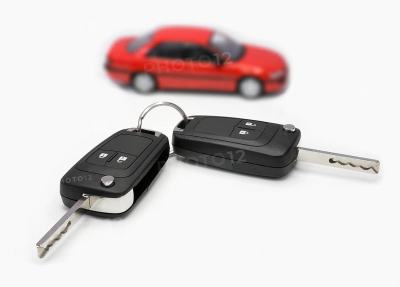Ignition keys with car in the background