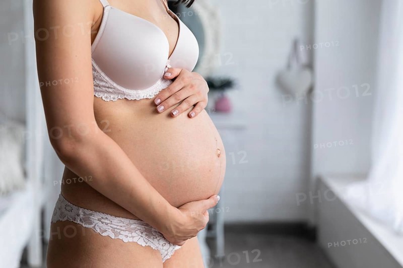 Side view pregnant woman touching her belly