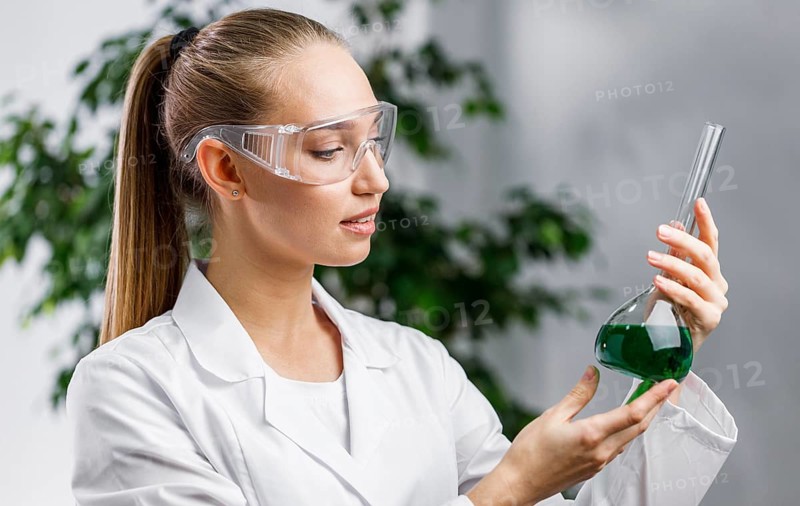 Side view female researcher with test tube safety glasses
