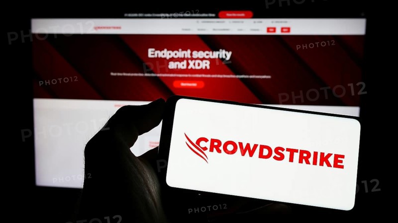 Stuttgart, Germany, 03-31-2023: Person holding smartphone with logo of cybersecurity company CrowdStrike Holdings Inc. on screen in front of website. Focus on phone display, Europe