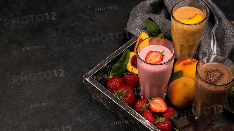 High angle milkshake glasses tray with chocolate fruits