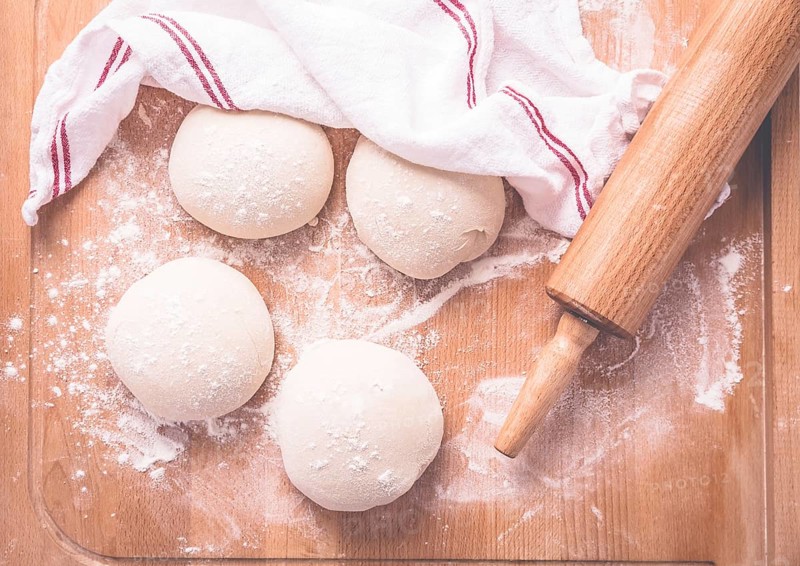 Yeast dough for making braided cakes, pies, pizza and rolls with rolling pin. Preparing leavened dough
