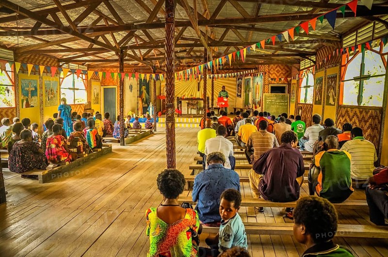Palembe, Papua New Guinea, July 2015: Photo of native people sitting on wooden benches during mass in wooden church in Palembe, Sepik river in Papua New Guinea. Documentary editorial, Oceania