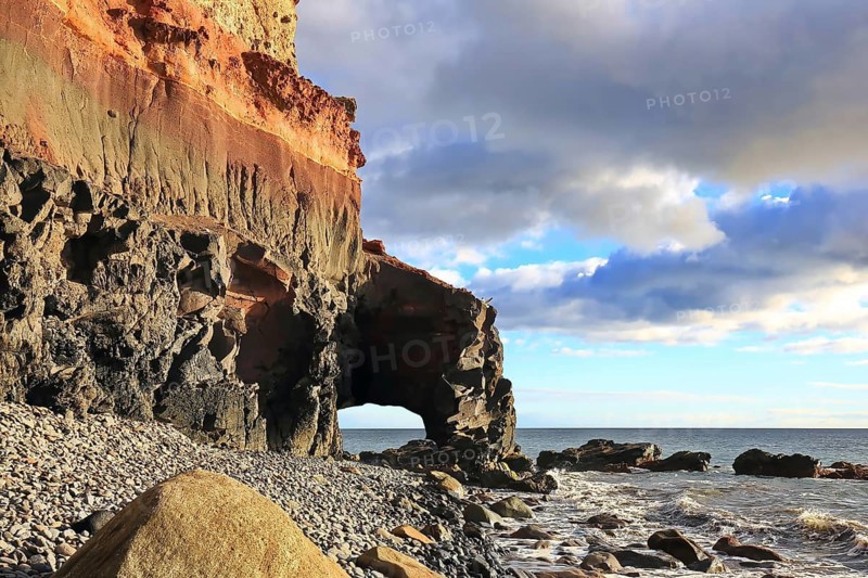 Lonely beach with a natural stone arch on the Atlantic Ocean in the Canary Islands. Playa de Tasarte, Las Palmas, Gran Canaria, Spain, Europe