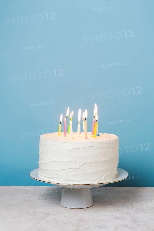Front view lit candles birthday cake. High resolution photo