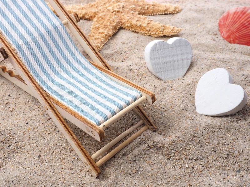 Blue deckchair with starfish in the sand on a beach