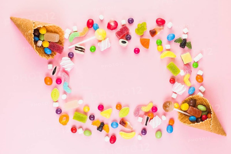 Colorful sweet candies with two ice cream waffle cone pink surface