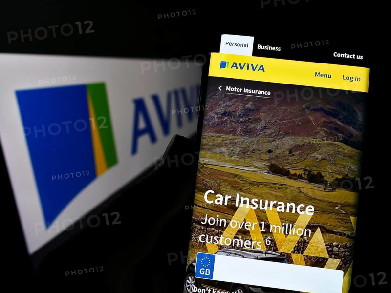 Stuttgart, Germany, 11-30-2022: Person holding smartphone with website of British insurance company Aviva plc on screen in front of logo. Focus on center of phone display, Europe