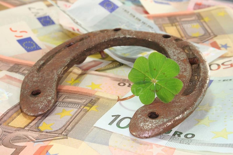 Rusty horseshoe with lucky clover and lots of euro notes