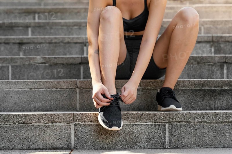 Front view woman tying her shoelaces before exercising