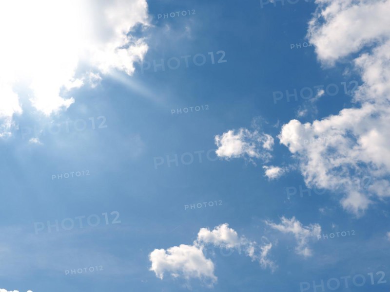 Bright hot sun on a blue summer sky with small clouds