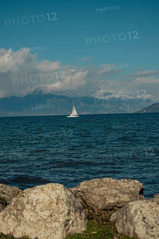 A sailing boat on Lake Garda in the sunshine, Sirmione, Lake Garda, Italy, Europe