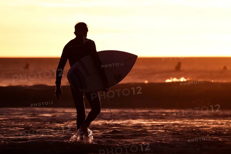 Bells Beach, Australia, January 30 2017: A surfer prepares to enter the water at the iconic Bells Beach on a summer morning at sunrise near Torquay, Victoria, Australia, Oceania