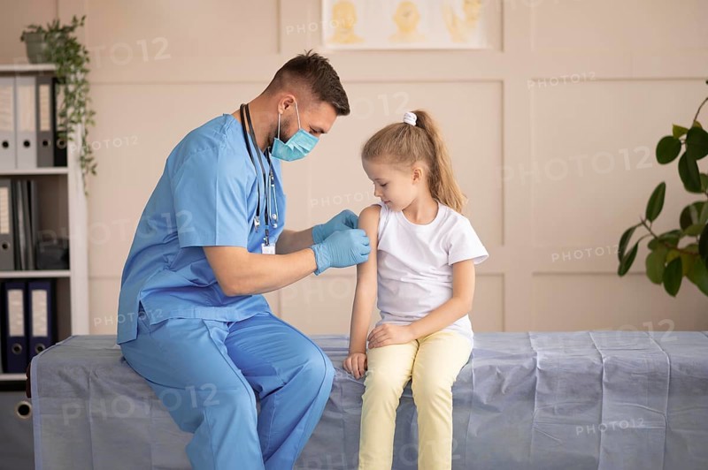 Young doctor vaccinating little girl
