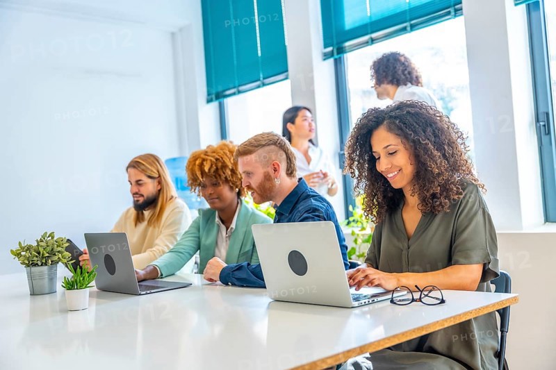 Dynamic side view of man and woman sitting in a coworking using laptop