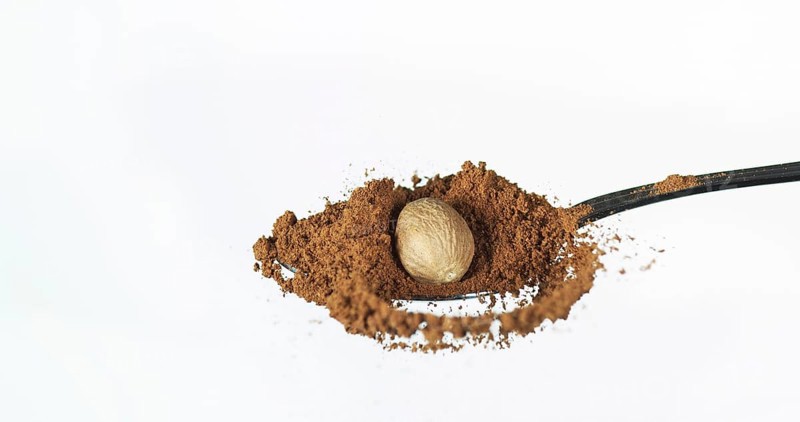 Nutmeg, myristica fragans, Powder falling against White Background