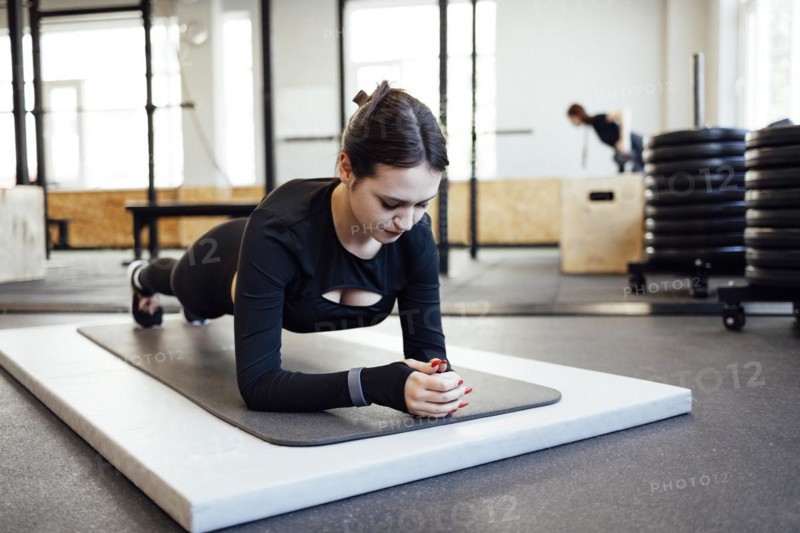 Young beautiful woman stretching and warming up before workout in fitness gym, Sport and healthcare concept
