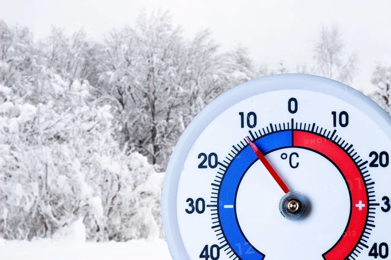 Thermometer below minus ten degrees Celsius, snow-covered bushes and trees