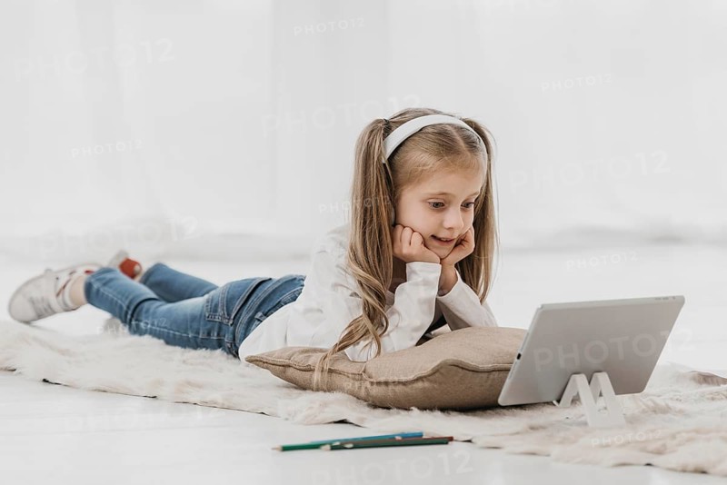 School girl wearing headphones attending online classes