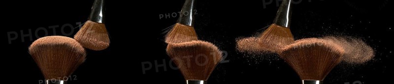 Make-up Brush spreading blush powder on black background