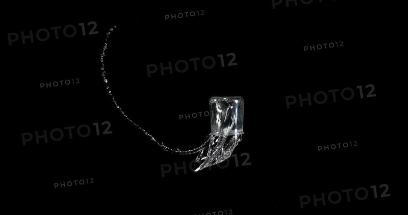Glass of Water Bouncing and Splashing on Black Background