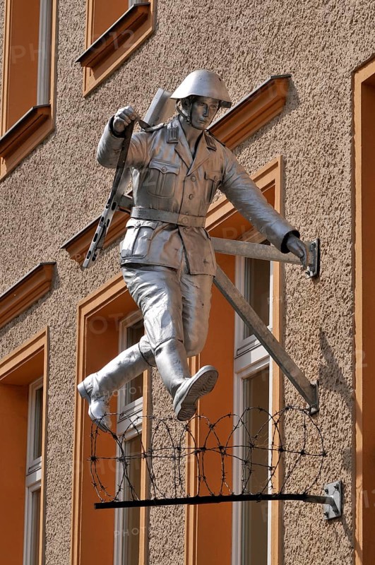 Jumping soldier, barbed wire, house wall, sculpture Jump, by Conrad Schumann, Wall memorial, Brunnenstraße, Bernauer Straße, Mitte, Berlin, Germany, Europe