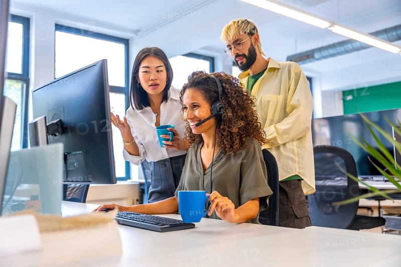 Coworkers drinking coffee while making a video call suing headset