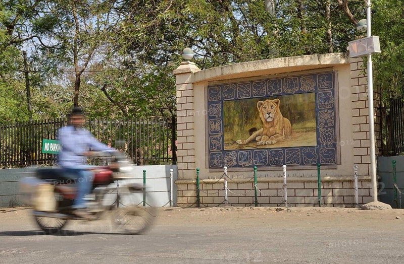 Motorcycle in front of the image of a lion, Asiatic Lion, outside the headquarters of the Forestry Commission, Gir Forest National Park, Gir Sanctuary, Sasan Gir, Gujarat, India, Asia
