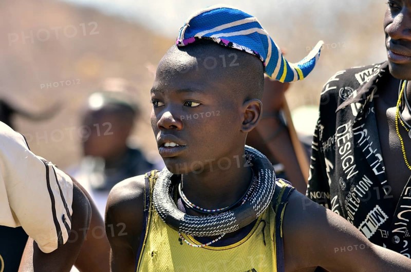 Young Himba man wearing a traditional headdress, cap in the form of a cattle horn, Omohanja, Kaokoland, Kunene, Namibia, Africa