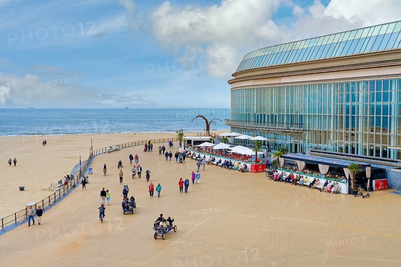 People walking and resting on Ostende promenade near the Kuursal casino, Ostende, West Flanders, Belgium, Europe