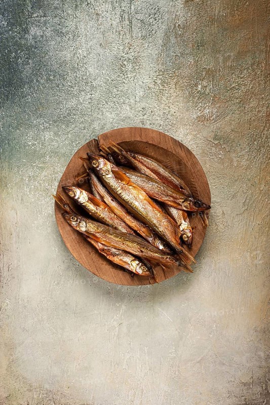 Cold smoked capelin, on a wooden bowl, top view, no people